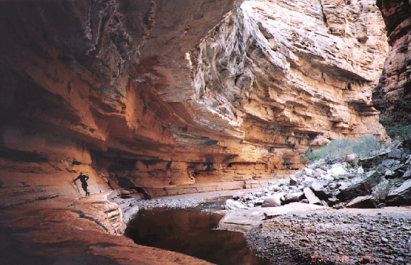 Steve under a roof - water undercuts harder layers at Kanab Canyon bend